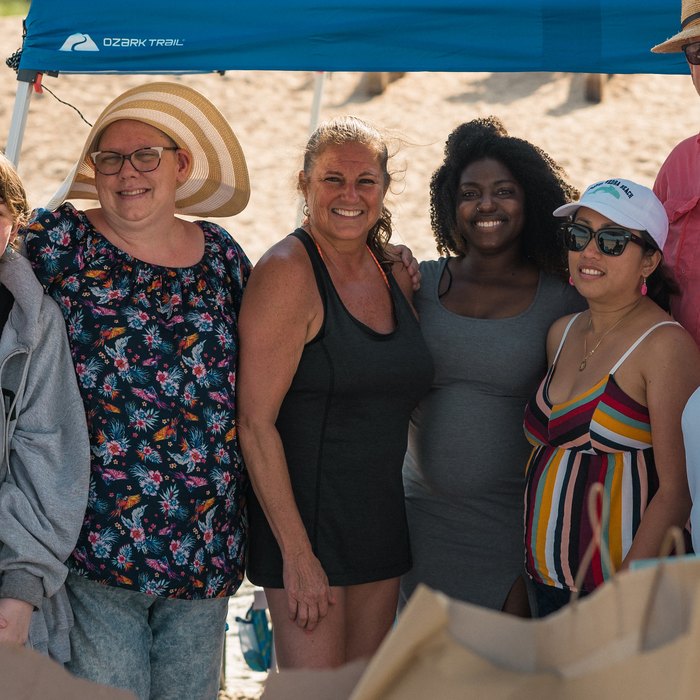 Lone Warrior families gathered under a tent at a beach day